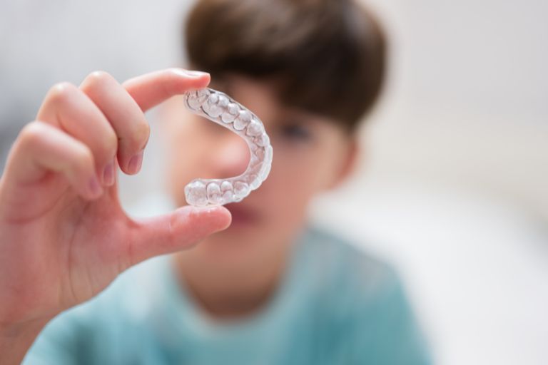 Niño mostrando Ortodoncia Invisible- Tipos de ortodoncia para niños - Ortodoncia en Avilés - Clínica Villalaín